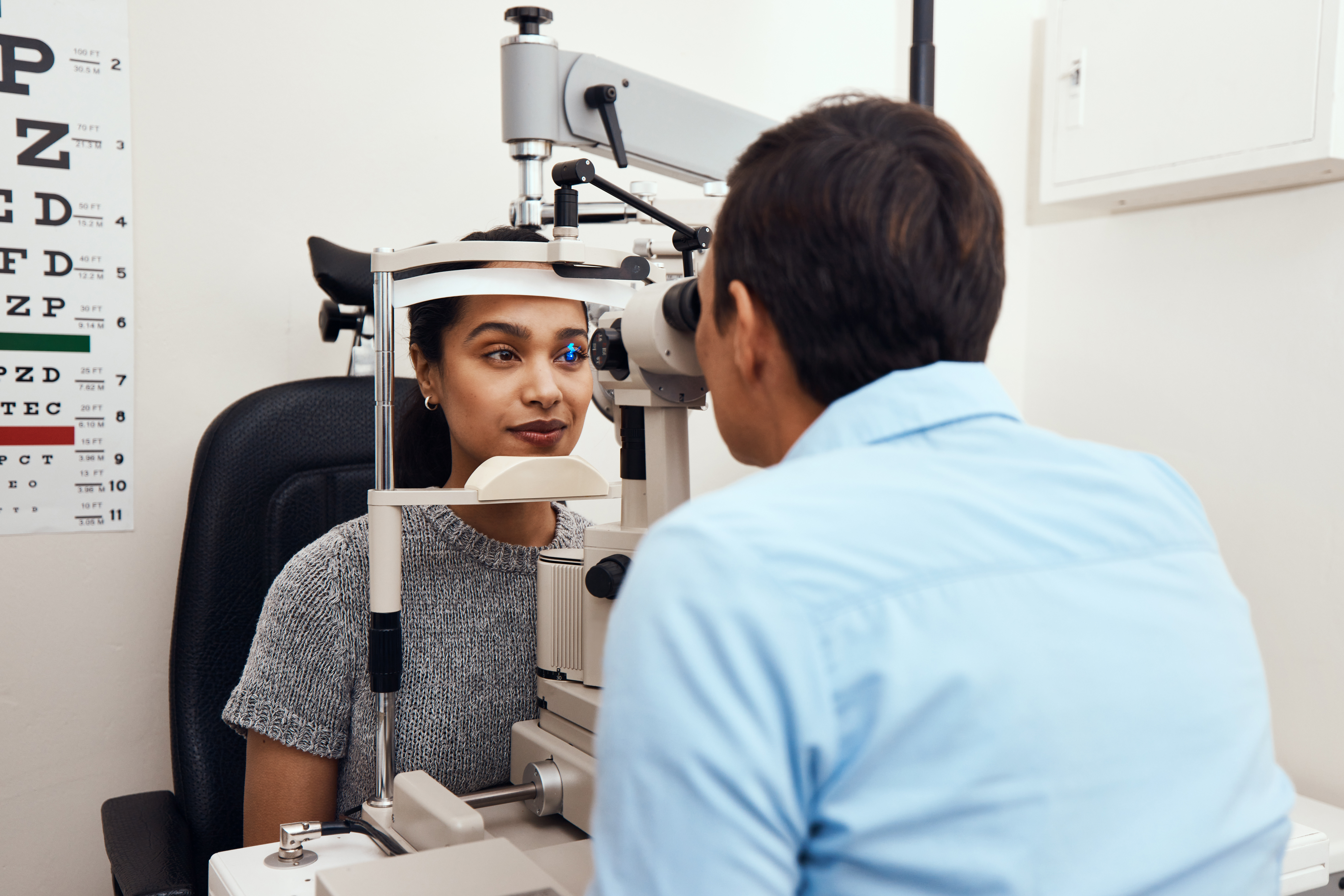 Can’t see Come to me. Shot of a young woman getting her eyes examined with a slit lamp by an optometrist.