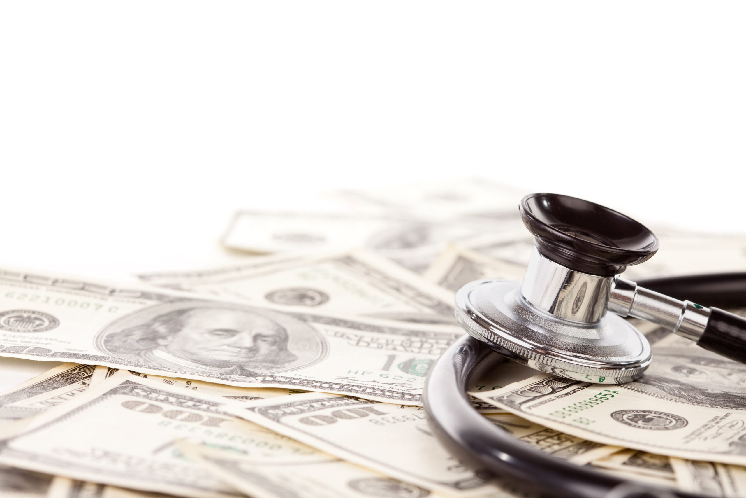 Stethoscope Laying on Stacks of Hundred Dollar Bills with Narrow Depth of Field.