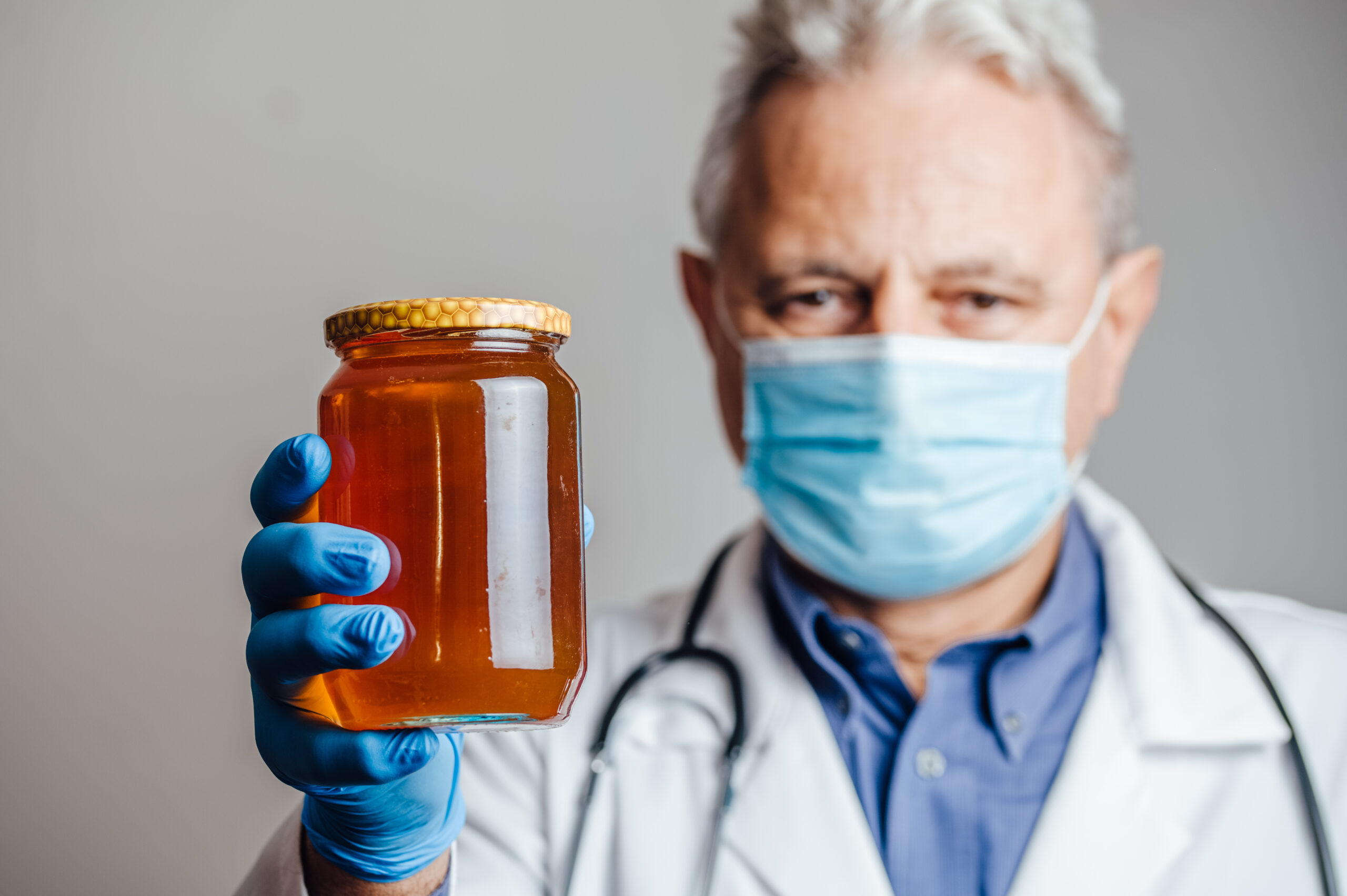 Medical doctor holding a jar of honey