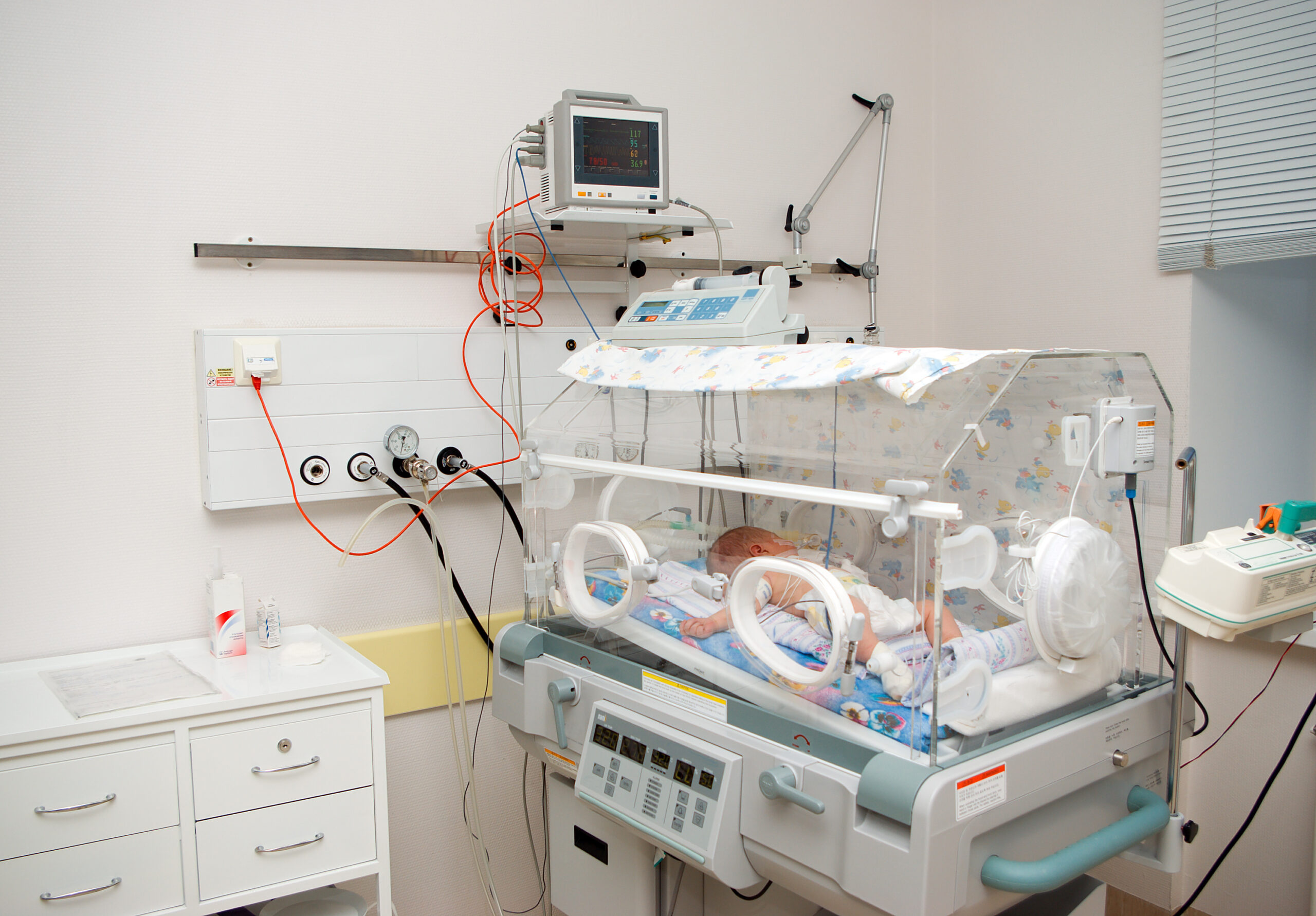 newborn baby sleeping in an incubator in hospital.