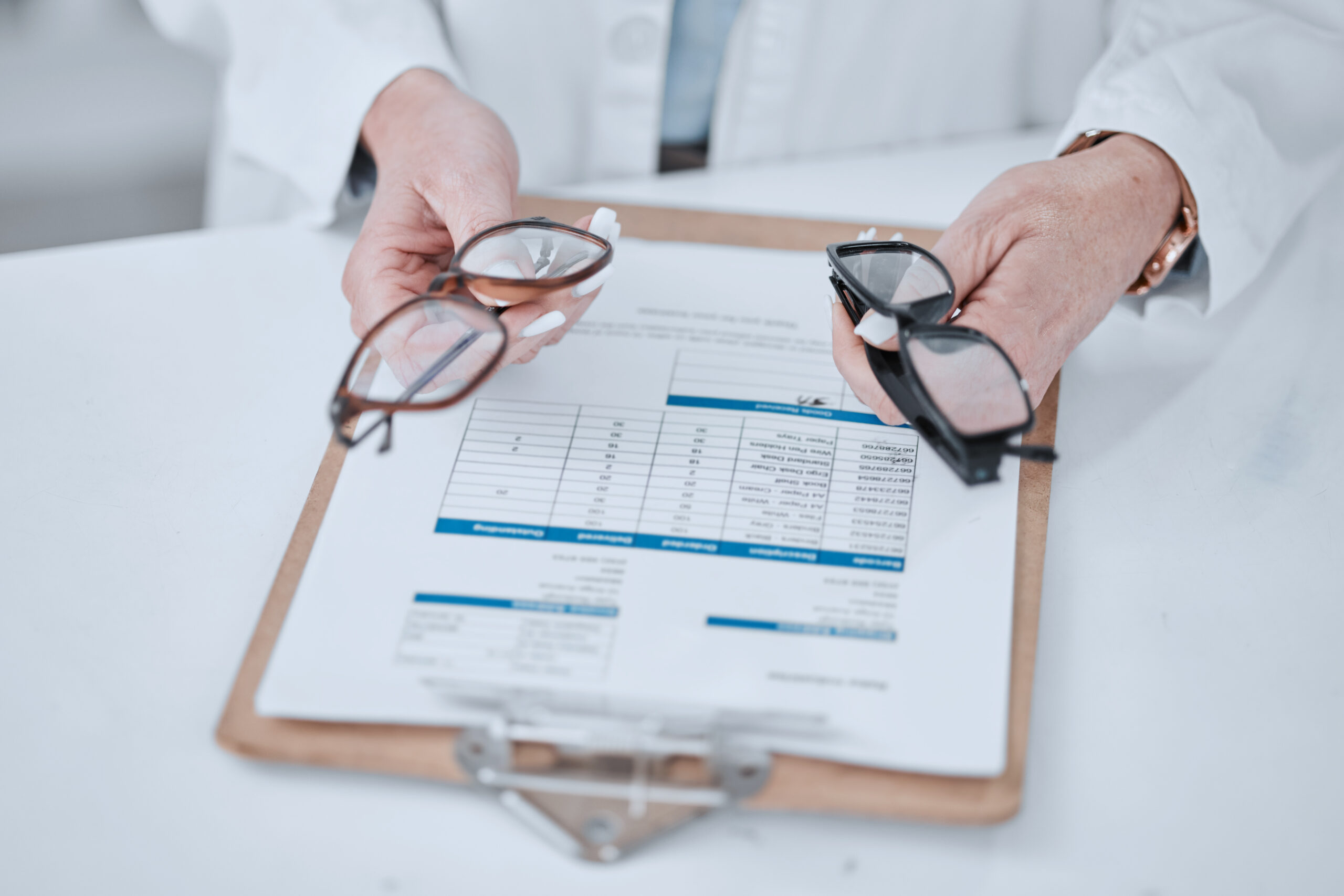 Clipboard, optometry and glasses for vision and eye care or wellness in an optical clinic. Checklist, medical and closeup of prescription spectacles with lens for optometrist or oculist treatment.